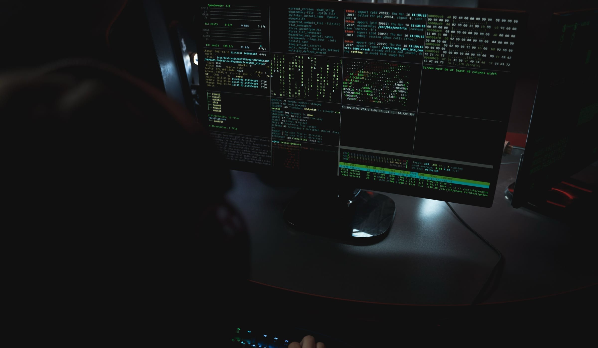Cyber security analyst monitoring system logs and network activity on a dark workstation